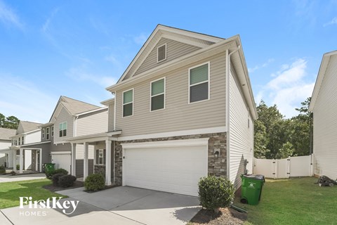 a beige house with a white garage door and a green lawn