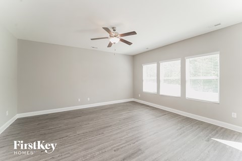 a living room with wood floors and a ceiling fan