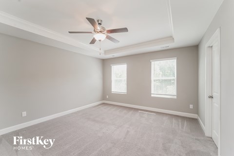 a bedroom with a ceiling fan and a carpeted floor