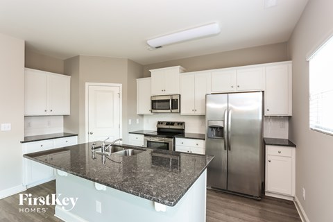 A kitchen with granite countertops and stainless steel appliances.