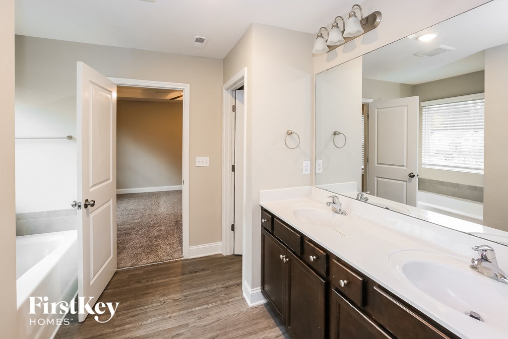A bathroom with a white tub and a white sink.