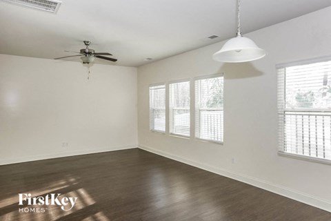 A spacious room with a ceiling fan and a hanging light fixture.