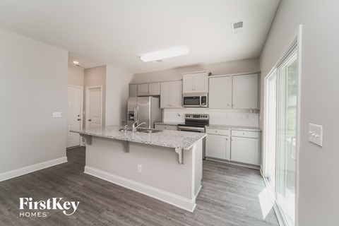 A kitchen with a white countertop and cabinets.