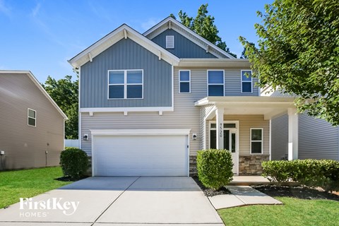 A modern house with a grey exterior and a white garage door.