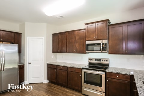 A kitchen with wooden cabinets and a stainless steel refrigerator.