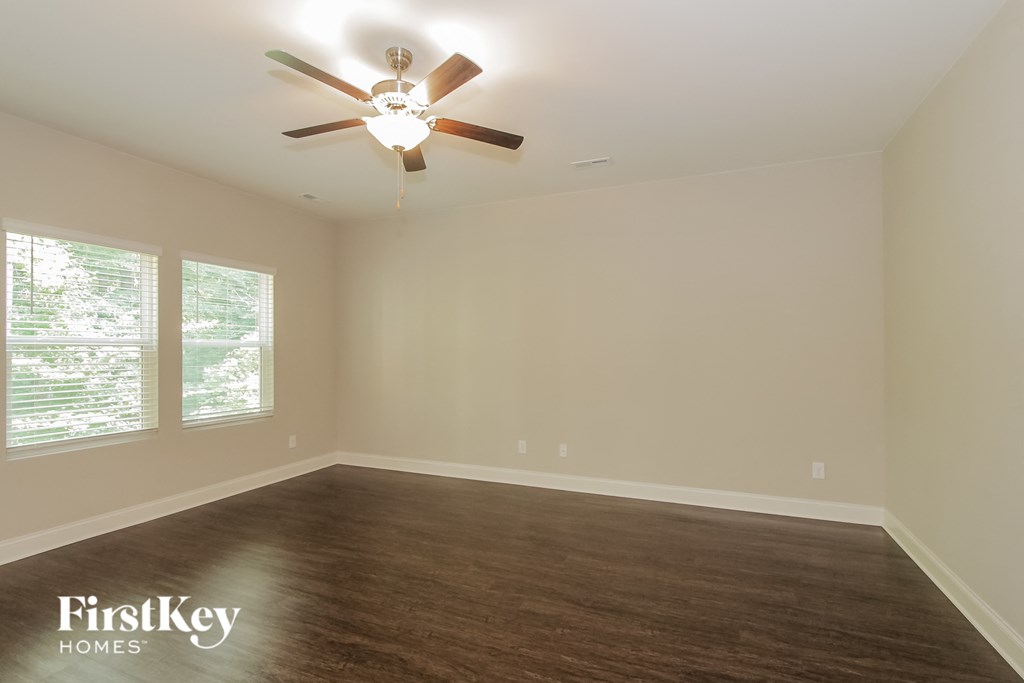an empty living room with a ceiling fan