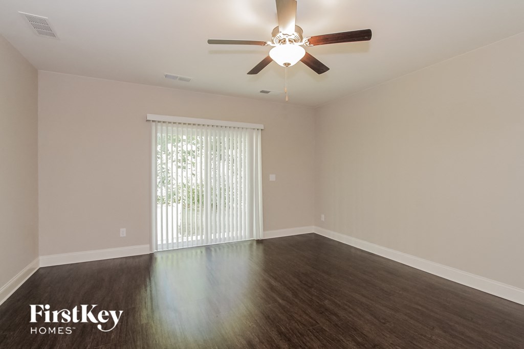 a living room with wood floors and a ceiling fan