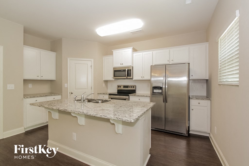 a kitchen with white cabinets and a granite counter top