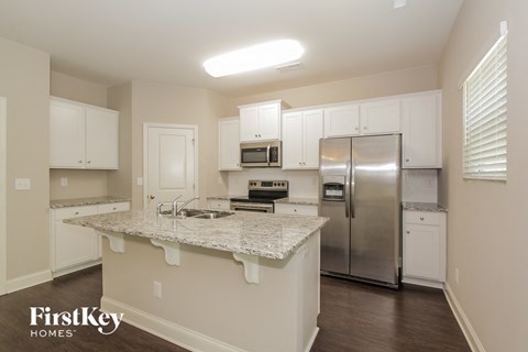 a kitchen with white cabinets and a granite counter top