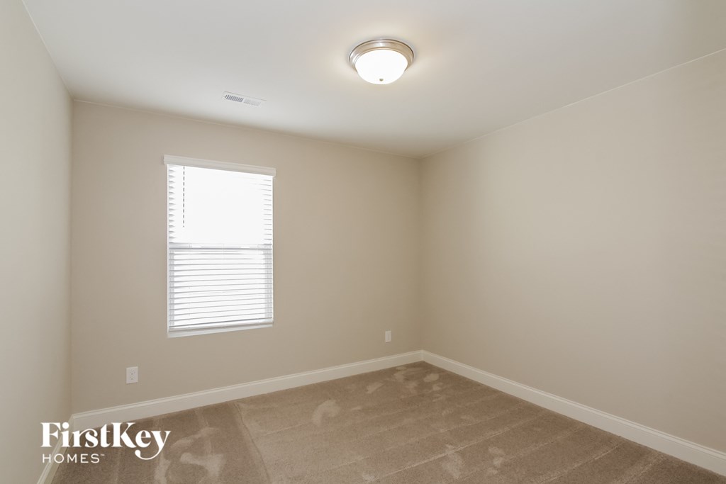 a empty room with a window and a ceiling light