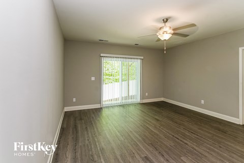 A room with a sliding glass door leading to a balcony.