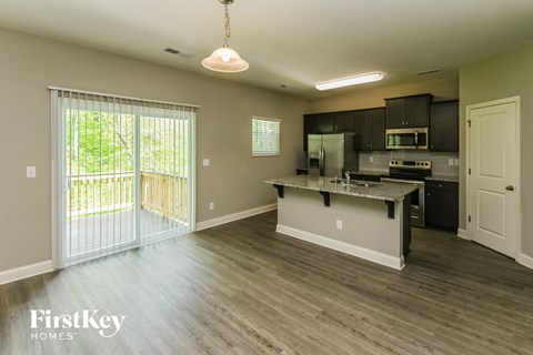 A kitchen with a dining table and a refrigerator.