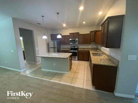 A kitchen with granite countertops and dark wood cabinets.
