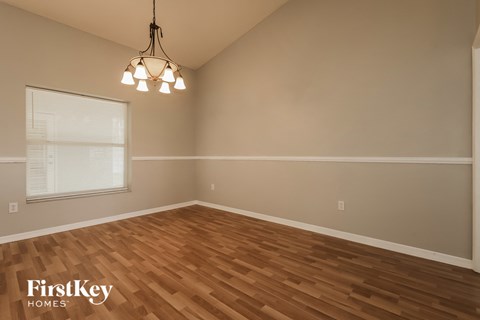 the living room of an empty house with wood floors and a window