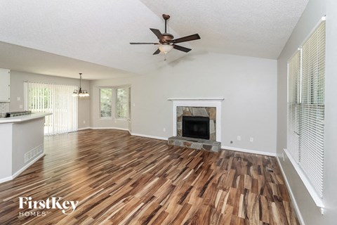 a living room with a fireplace and a ceiling fan