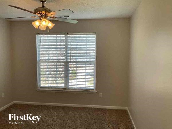 an empty room with a ceiling fan and a window