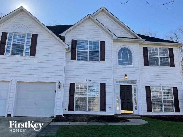 a white house with black shutters and a driveway
