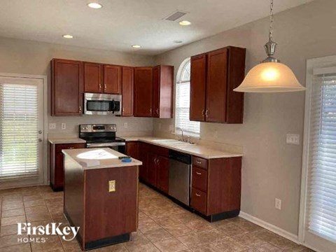 a kitchen with wooden cabinets and a stove and a sink