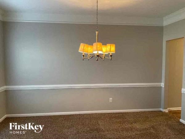 a dining room with a yellow chandelier
