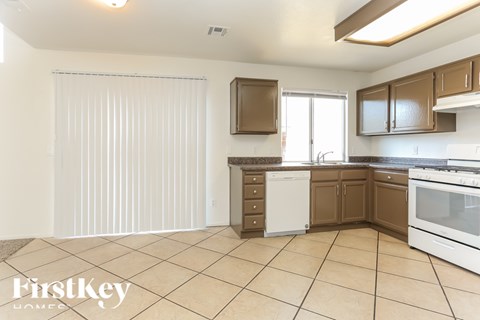 A kitchen with brown cabinets and white appliances.