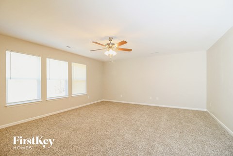 a bedroom with carpet and a ceiling fan