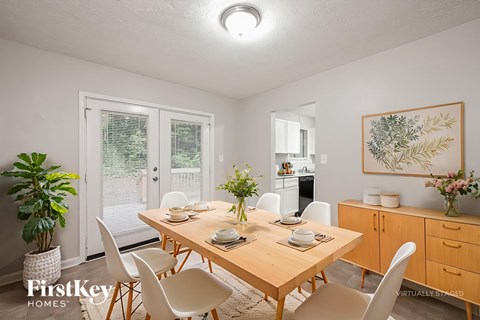 A dining room with a wooden table set for four.