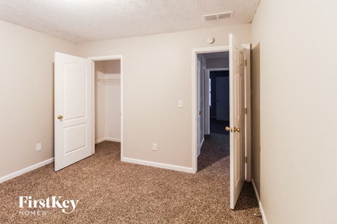a bedroom with a carpeted floor and a door to a closet