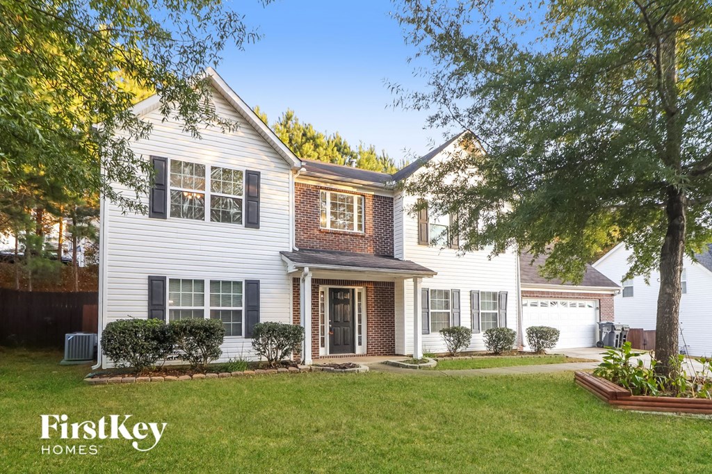 a white house with black shutters and a lawn