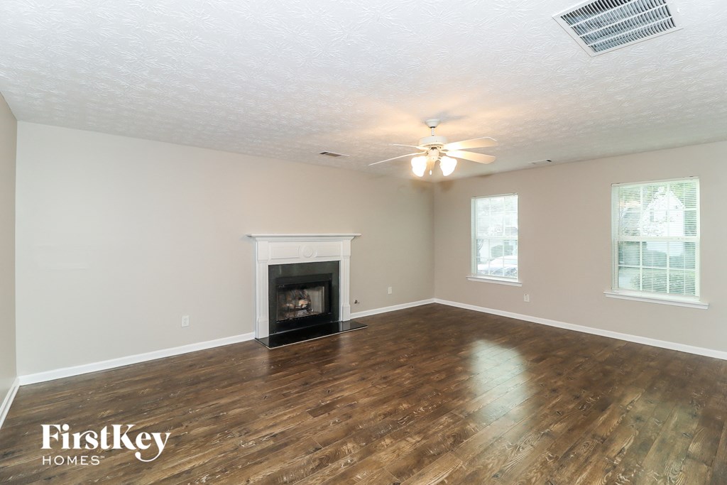the living room with wood flooring and a fireplace