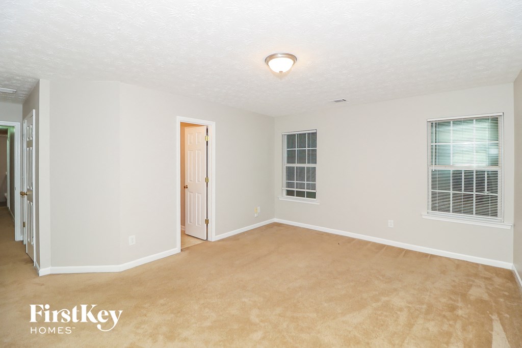 a bedroom with a carpeted floor and a door to a closet