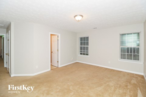 a bedroom with a carpeted floor and a door to a closet