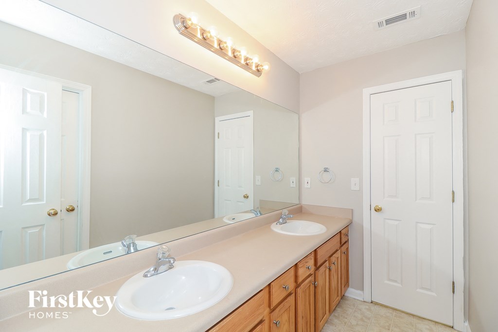 a bathroom with two sinks and a large mirror