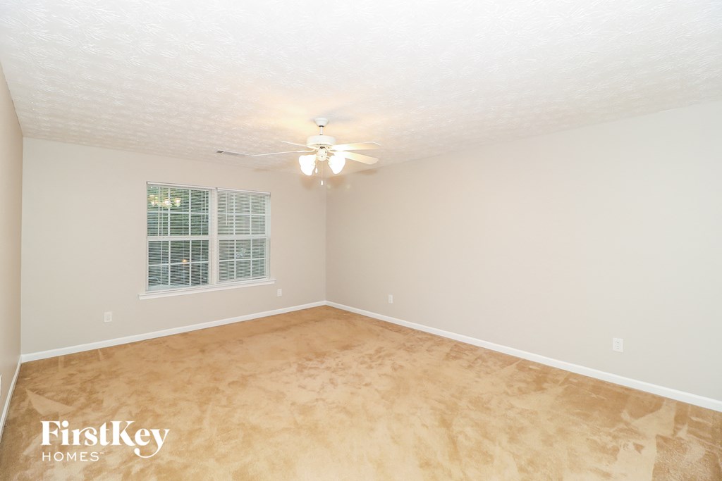 a bedroom with a carpeted floor and a ceiling fan