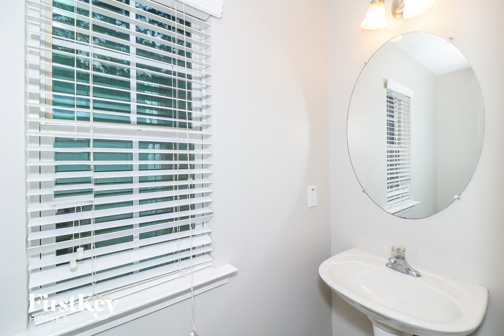 a bathroom with a sink and a mirror and a window