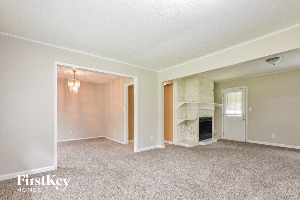 a living room with a fireplace and a door into a hallway