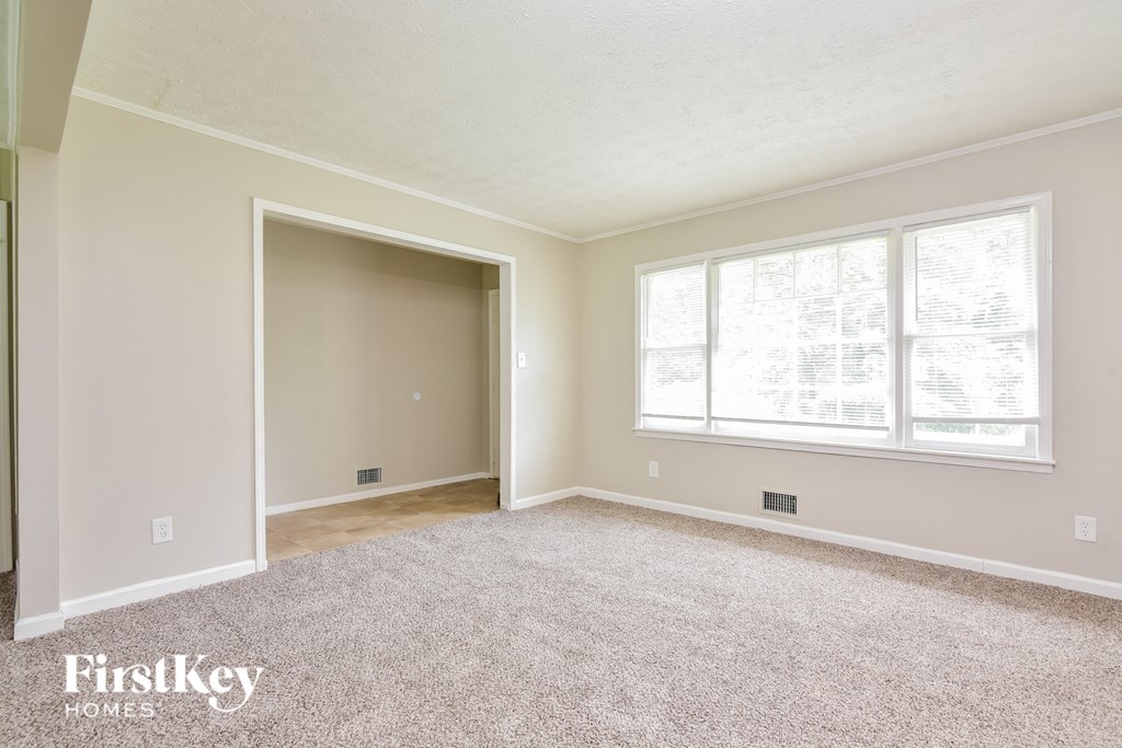a bedroom with a carpeted floor and a large window