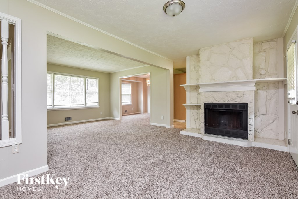 a living room with a fireplace and a carpeted floor