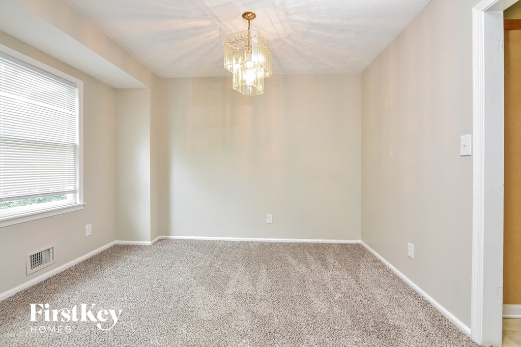 a empty room with a chandelier and a window