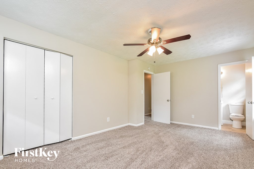 a bedroom with a ceiling fan and a closet