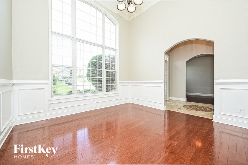 an empty living room with a large window and wood floors