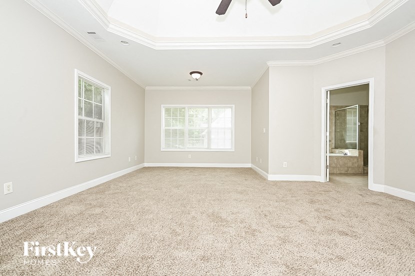 the master bedroom is spacious and has a large window and carpeting