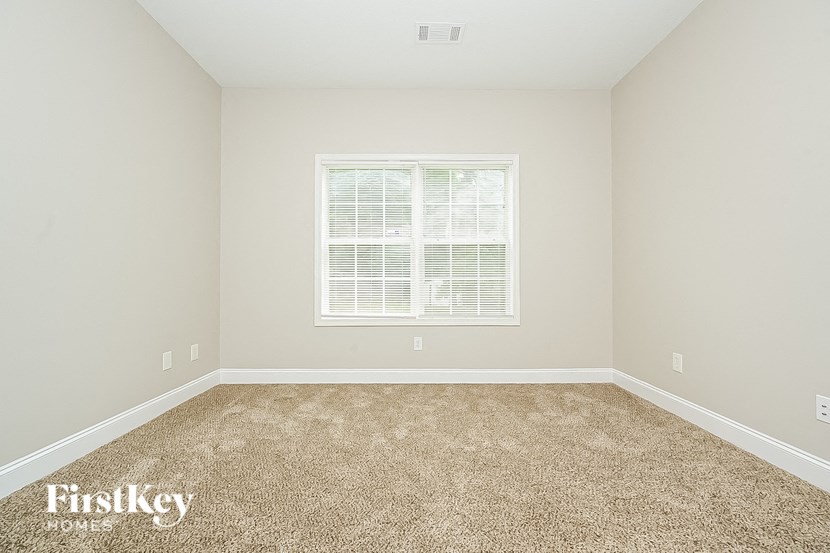 a empty room with carpet and a window