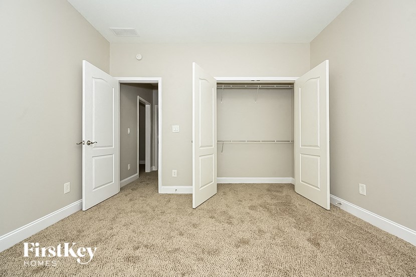 a bedroom with two closets and a carpeted floor
