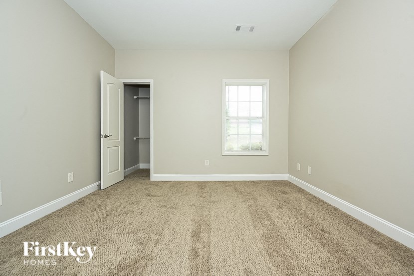 a empty room with carpet and a door to a closet