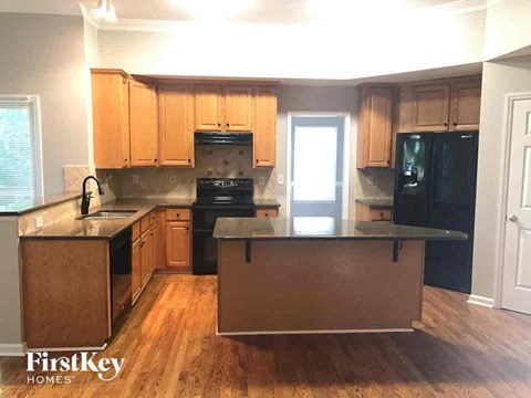 A kitchen with wooden cabinets and black appliances.