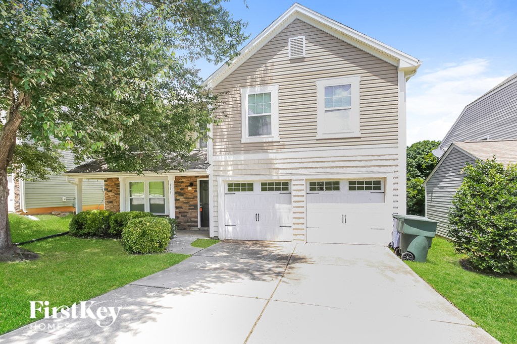 a white and brown house with two garage doors