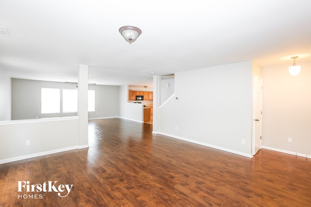 an empty living room with wood flooring and white walls