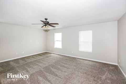 a living room with carpet and a ceiling fan