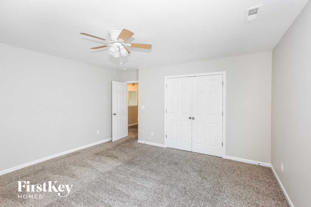 a living room with carpet and a ceiling fan
