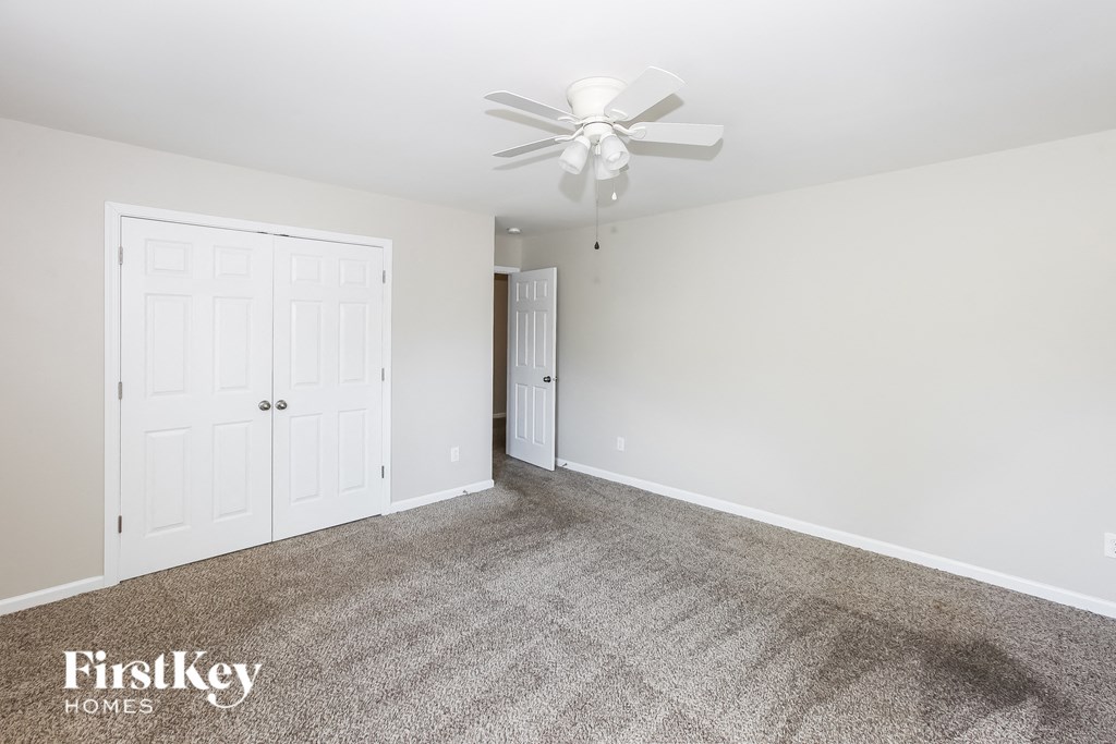 a bedroom with carpet and a ceiling fan